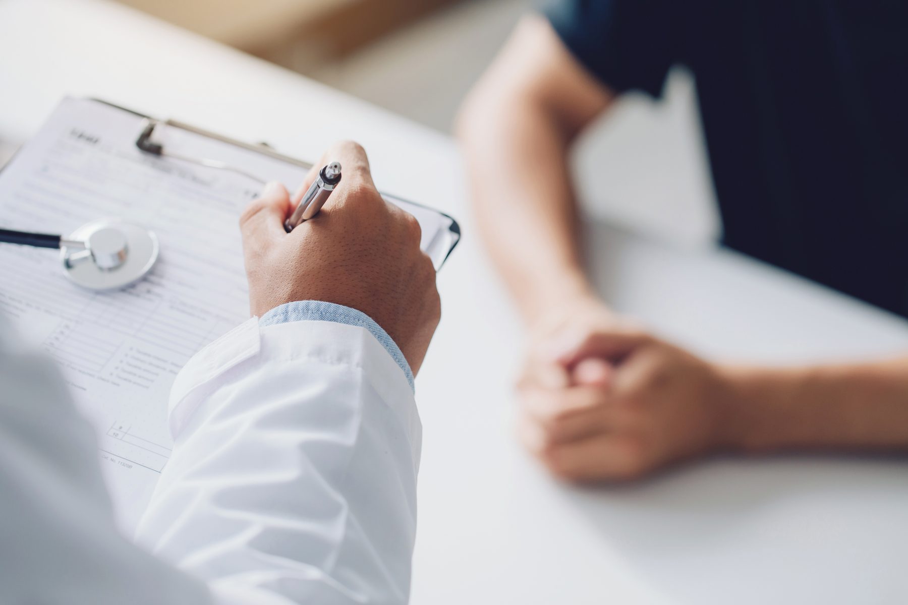 Clinician and patient in consultation, hands