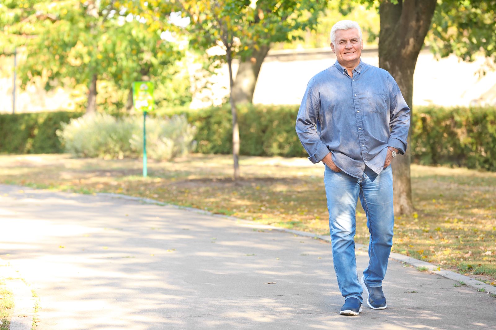Man walking alone through a park, thinking