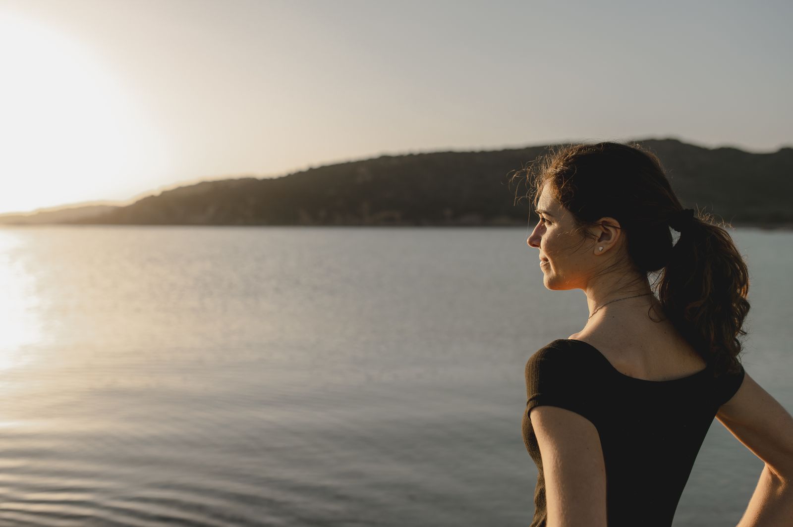 Woman by the sea, looking to the horizon
